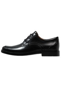 Scarpe eleganti nere in pelle, con finitura liscia, punta arrotondata, design con lacci e dettagli di cucitura sottili sulla parte superiore. Suola in gomma piatta.
