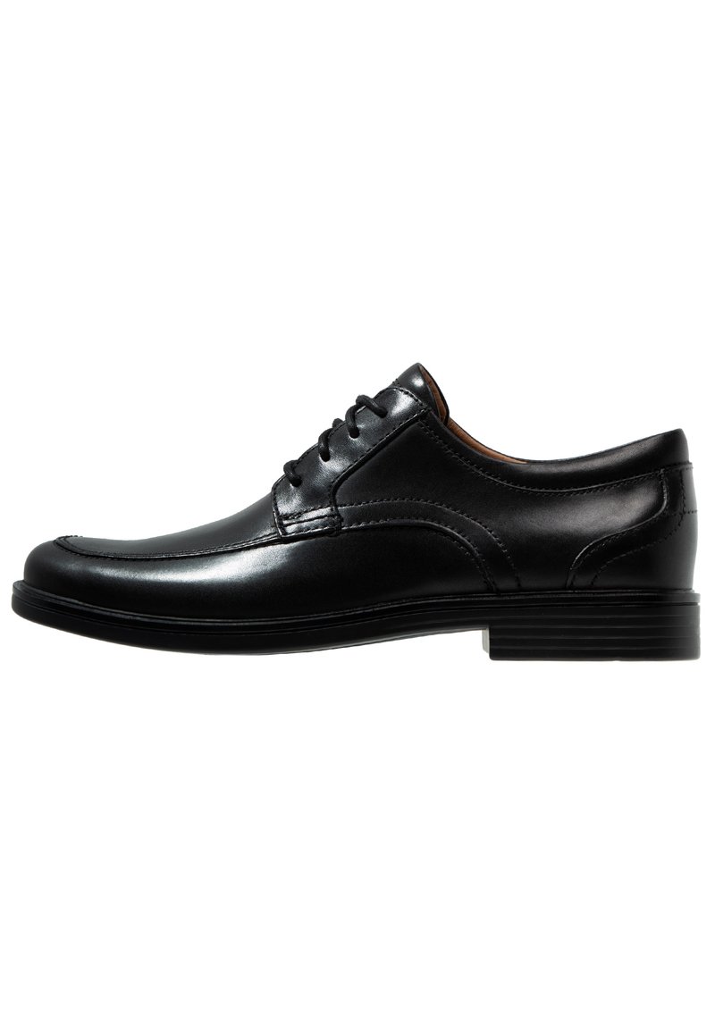 Scarpe eleganti nere in pelle, con finitura liscia, punta arrotondata, design con lacci e dettagli di cucitura sottili sulla parte superiore. Suola in gomma piatta.