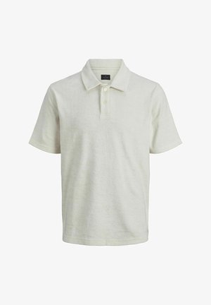 Polo gris clair avec un col, associé à un short en denim noir. Le modèle porte des chaussettes blanches et des baskets noires avec des accents blancs.