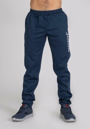 Pantalones de chándal azul marino hechos de una mezcla de algodón, con cintura elástica y logo impreso "Joma" en la pierna izquierda.
