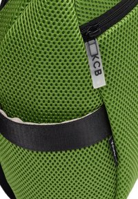 Mochila de malla verde con superficie texturada, correa negra y detalles de cremallera. Presenta una etiqueta KCB en el lateral.