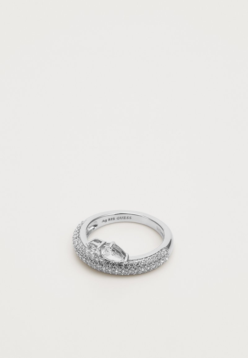 Bague en argent massif au design torsadé, ornée de petits diamants et d'une pierre en forme de goutte d'eau au centre, marquée "Ag 925 GUESS" à l'intérieur.