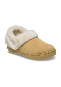 Zuecos de ante marrón claro con un suave forro de piel de crema, puntera redondeada y suela de goma texturizada. Presenta un puño doblado y costuras sutiles.