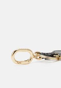 Black leather keychain with a gold-tone metal clasp. Features a smooth texture and circular ring for attachment. Simple and functional design.