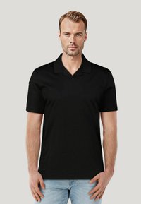 Czarna koszulka polo z krótkim rękawem, z płaskim kołnierzykiem i prostym krojem. Wykonana z miękkiego materiału, charakteryzująca się minimalistycznym designem i brakiem widocznych wzorów.