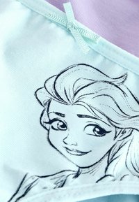 Ljust blått tygbehå med ett grafiskt tryck av en karaktärs ansikte. Inkluderar tunna axelremmar och en söm med en liten rosett som accent.