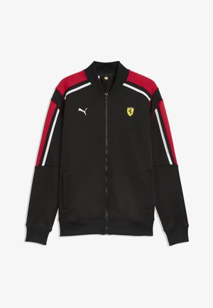 Schwarze Jacke mit Reißverschluss und roten sowie weißen Streifen auf Schultern und Ärmeln, mit Puma-Logo und Ferrari-Wappen auf der Brust.