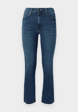 Jeans de denim azul oscuro con cintura de altura media, corte ajustado y dobladillo acampanado con un sutil detalle de costura.