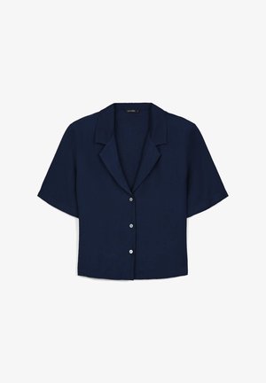 Chemise bleu marine à manches courtes avec un col à revers, présentant une texture lisse et cinq boutons ronds sur le devant.