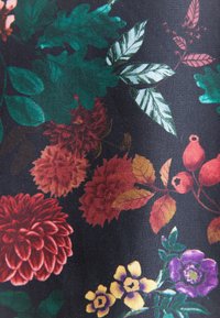 Tessuto floreale con fiori vivaci e multicolori in tonalità di rosso, giallo e viola su uno sfondo nero, con foglie verdi e accenti.