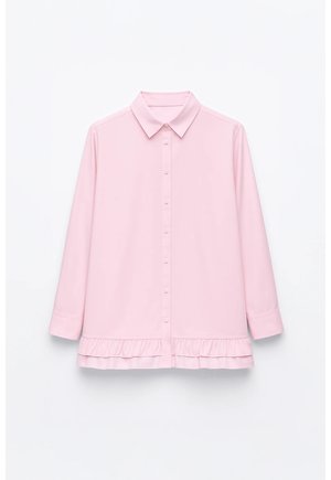 Chemise boutonnée rose avec col, manches trois-quarts et ourlet à volants, confectionnée dans un tissu à la texture lisse.