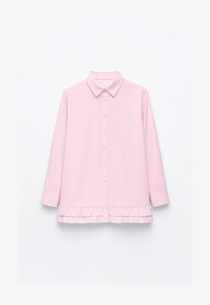 Różowa koszula na guziki z kołnierzykiem, rękawami do łokcia i falbanką u dołu, wykonana z gładkiej tkaniny.