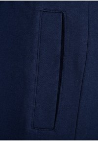 Navy blue knit fabric with a smooth texture; features a side pocket with a clean, straightforward design.