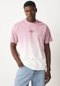 Roosa gradiendiga T-särk pehmest kangast, mille keskosas rinnal on tumedas kirjas trükitud tekst "Shibuya City, Tokyo, Japan". Lühikesed varrukad, mugav lõige.