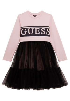 Vestido de manga larga color rosa con falda de tul negra y una ancha banda negra cruzando el pecho con el logo "GUESS" en letras rosas.