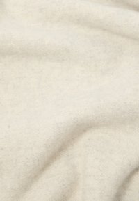 Lys beige stoff med en myk, teksturert overflate; ser litt melert ut med subtile fargevariasjoner og fint vevd mønster.