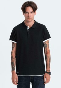 Zwarte poloshirt met witte kraag en accenten op de mouwen, korte mouwen, drieknopenpolo en een gladde katoenstructuur.