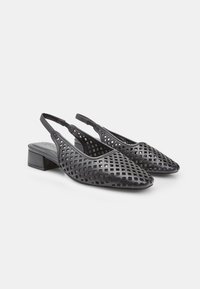 Zapatos slingback negros con un patrón de cuadrícula recortado, punta afilada y tacón bajo de bloque, con una textura suave y una correa ajustable.