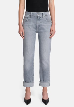 Lichtblauwe denim jeans met een rechte pijp, opgerolde zoom, vijf zakken en een lichte vervaging. Gemaakt in combinatie met een zwart aansluitend topje en hakken.