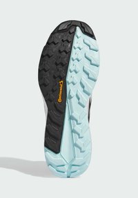 Semelle de chaussure de sport noire et bleu clair avec un motif de profil multi-directionnel texturé. Comprend le logo Continental en orange.