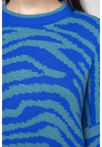 Stickad tröja med ett mönster av zebrasträck i blått och teal. Ribbad rund hals och strukturerad tyg med kontrasterande färger genom hela.
