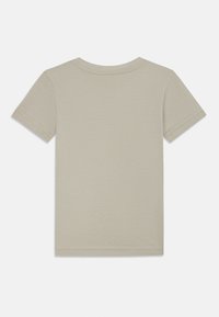 T-shirt à manches courtes en coton beige clair. Présente un col rond et un design épuré avec ourlet et manches cousus. Sans graphismes.