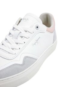 Sneaker bianca con dettagli in pelle e suede. Presenta lacci bianchi, un tallone rosa e un logo impresso. Punta arrotondata e suola testurizzata.