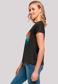 Black T-shirt with short sleeves featuring a colorful mountain graphic in orange, teal, and blue on the front; casual fit.