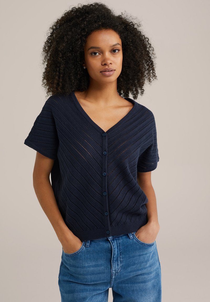 Tums blue adīts kardigāns ar īsām piedurknēm, V veida kaklu un horizontālu ribu rakstu, ar sešām pogām priekšpusē.