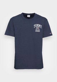 Námořnická modrá bavlněná tričko s bílým logem "TOMMY JEANS" na levé části hrudi a malým logem na rukávu. Design s kulatým výstřihem.