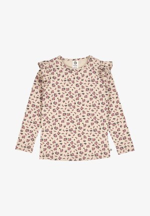 Pitkähihainen kerma-pusero, jossa on vaaleanpunainen ja musta kukkakuvio; reunuksena röyhelöt olkapäiden kohdalla. Valmistettu pehmeästä tekstiilimateriaalista.