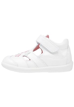 Sandale blanche pour tout-petit avec sangle en velcro, broderie florale rose et blanche, et détails découpés sur le côté et le bout du pied.