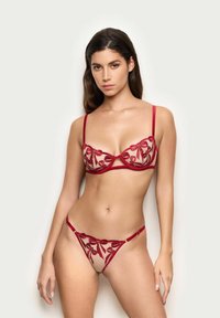 Rød broderet lingeri sæt med gennemsigtigt materiale, blomstermønster, bøjlestøttet bh og minimalistisk trusse med justerbare stropper.