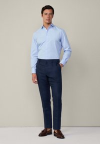 Camicia d'eleganza a righe azzurro chiaro, pantaloni blu navy, mocassini marroni. Design slim fit con forma su misura, texture liscia. Stile minimalista.