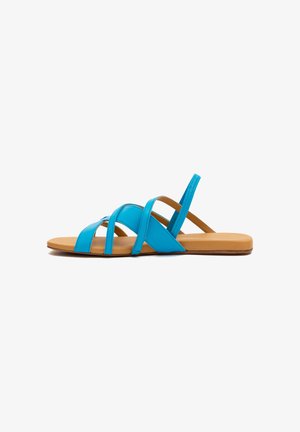 Flache Sandale mit beigefarbener Sohle und mehreren leuchtend blauen Lederriemen, einschließlich eines Riemens für die Fersenunterstützung, im Seitenprofil gezeigt.
