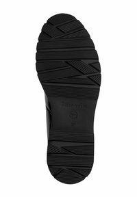 Černá gumová podrážka boty s texturovaným vzorem, obsahující horizontální a diagonální drážky. Označeno "Tamaris" a velikost "37".