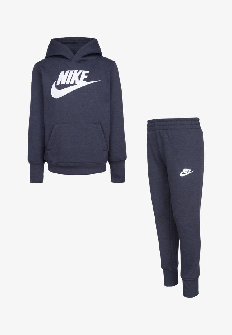 Conjunto de hoodie azul-marinho e calças de treino combinando, feito em mistura de algodão. O hoodie tem um bolso frontal e um logótipo da Nike em branco; as calças apresentam uma cintura elástica.