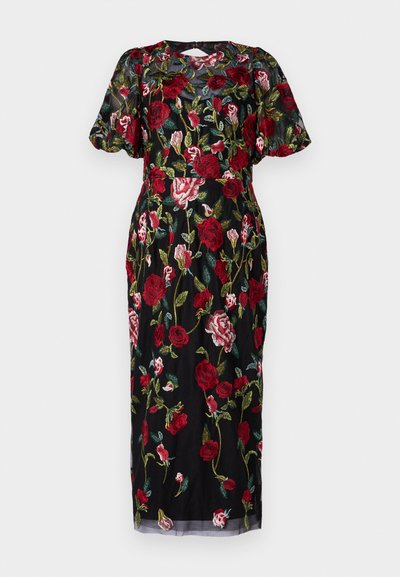 Melna kleita ar ziedu izšuvumiem sarkanos, rozā un zaļos tonī. Caurspīdīgs materiāls, īsas pūkainas piedurknes un vidēja garuma dizains ar atslēgas caurumu aizmugurē.