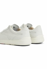 Sneaker bianchi in pelle con design perforato sui lati, suole imbottite e suola in gomma nera a contrasto.