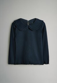 Námornícky modrý top s dlhým rukávom, s volánovým golierom a zapínaním na gombíky na chrbte. Textúrovaná látka s mierne voľným strihom a volánovým lemom.