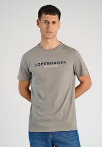 Grijze katoenen T-shirt met korte mouwen, ronde halslijn, met "COPENHAGEN LINDBERGH" in marineblauw op de borst gedrukt. Casual fit.