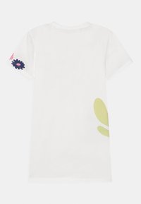 Vit t-shirt med en grön bladdesign på högra sidan och blomsterdetaljer i rosa och marinblått på ärmarna. Korta ärmar, rund hals.