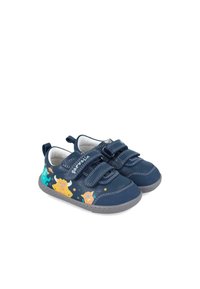 Zapatos de lona para niños pequeños de color azul con correas de Velcro dobles, suelas grises y gráficos de monstruos alegres en colores vivos a los lados.