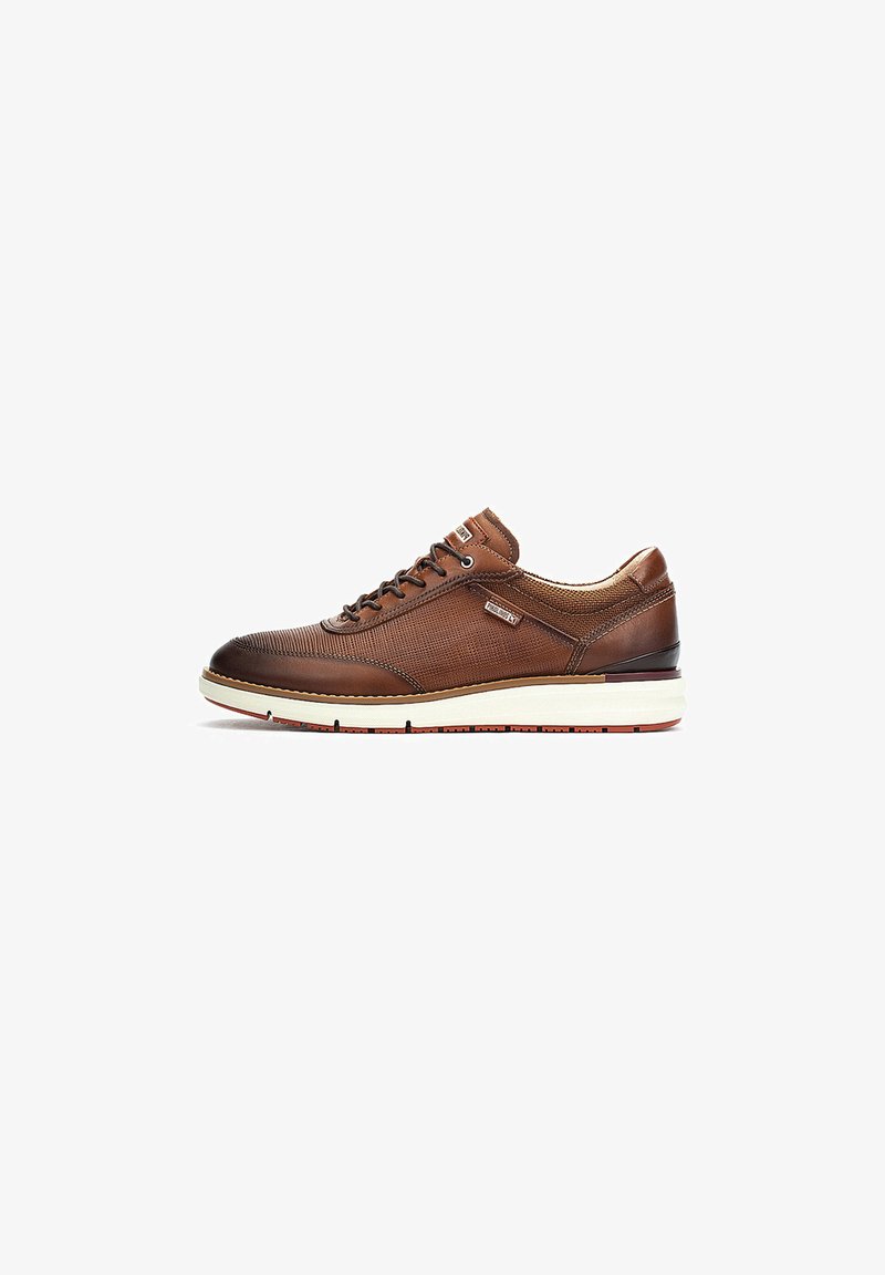 Sneaker en cuir marron avec un dessus texturé, des semelles contrastantes et un design à lacets. Présente des perforations et un col rembourré pour le confort.