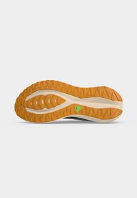 Semelle de chaussure avec une bande de roulement orange et une partie médiane beige présentant un petit détail triangulaire vert, montrée sur un fond clair uni.