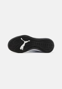 Suola di scarpa in gomma nera con un motivo testurizzato, caratterizzata da un logo Puma bianco. Il design include una forma arrotondata e bordi rinforzati.