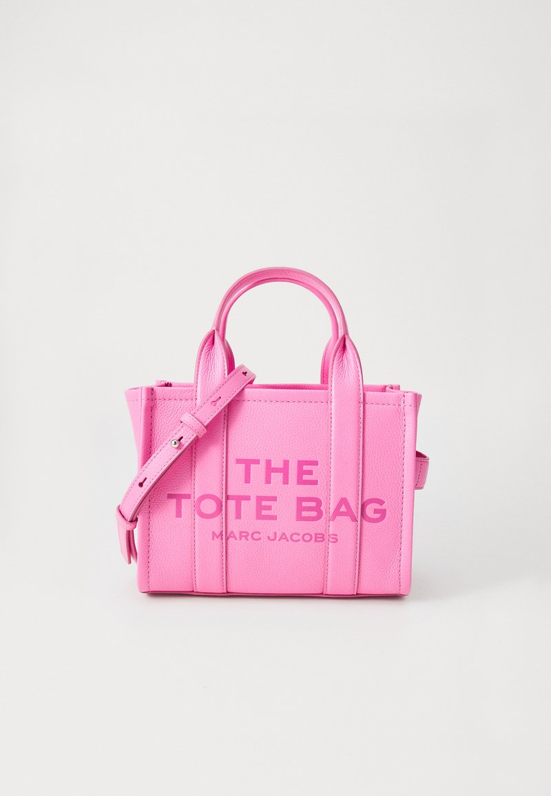 Borsa tote in pelle rosa brillante con due manici e una tracolla regolabile, "THE TOTE BAG MARC JACOBS" in rilievo sulla parte anteriore.