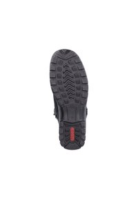 Semelle de chaussure en caoutchouc noir avec un motif de relief texturé, arborant un logo rouge et une construction durable pour une traction et une stabilité optimales.