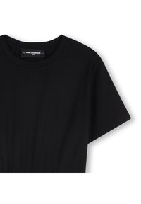 Μαύρο φόρεμα με κοντά μανίκια από μαλακό ύφασμα, με στρογγυλή λαιμόκοψη και λεπτομέρεια ζώνης στη μέση. Μινιμαλιστικός σχεδιασμός χωρίς ορατά μοτίβα ή μεταλλικά στοιχεία.