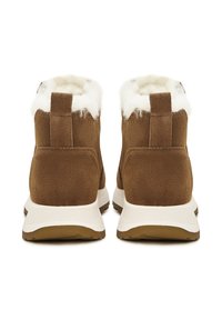 Bruine suède enkellaarzen met witte bontvoering en gevoerde zolen. Voorzien van een aantreklipje aan de achterkant en een slijtvaste rubberen buitenzool.